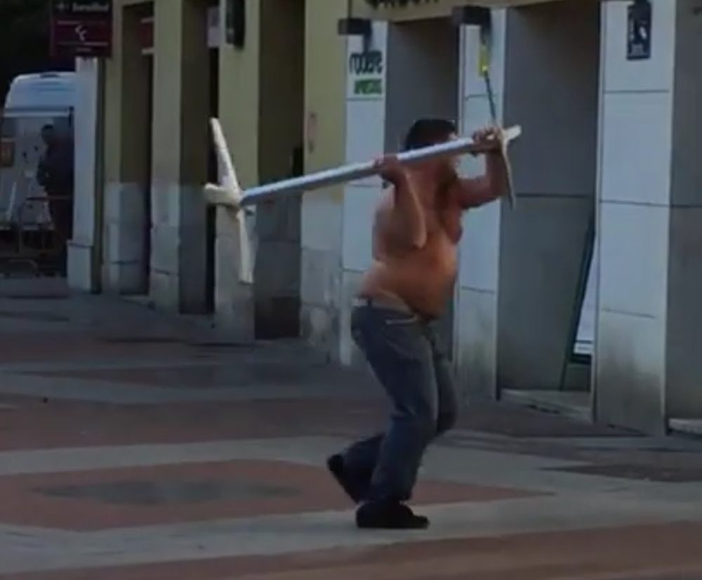 El hombre, sin camiseta, atacando comercios y escaparates de plaza de España.