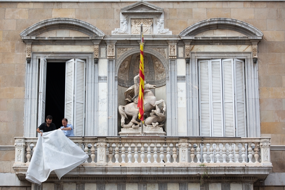El personal de la Generalitat retira el lazo de la fachada