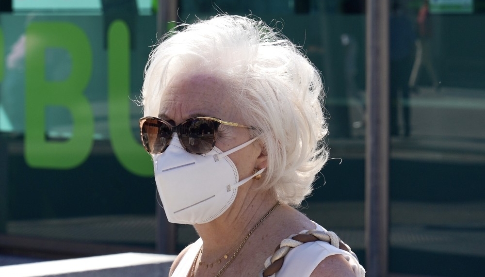 Una mujer cumple la norma de uso de la mascarilla en la vía pública