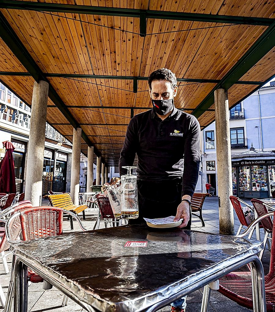 Roberto Harina, del Colmadito, recogiendo una mesa de su terraza.