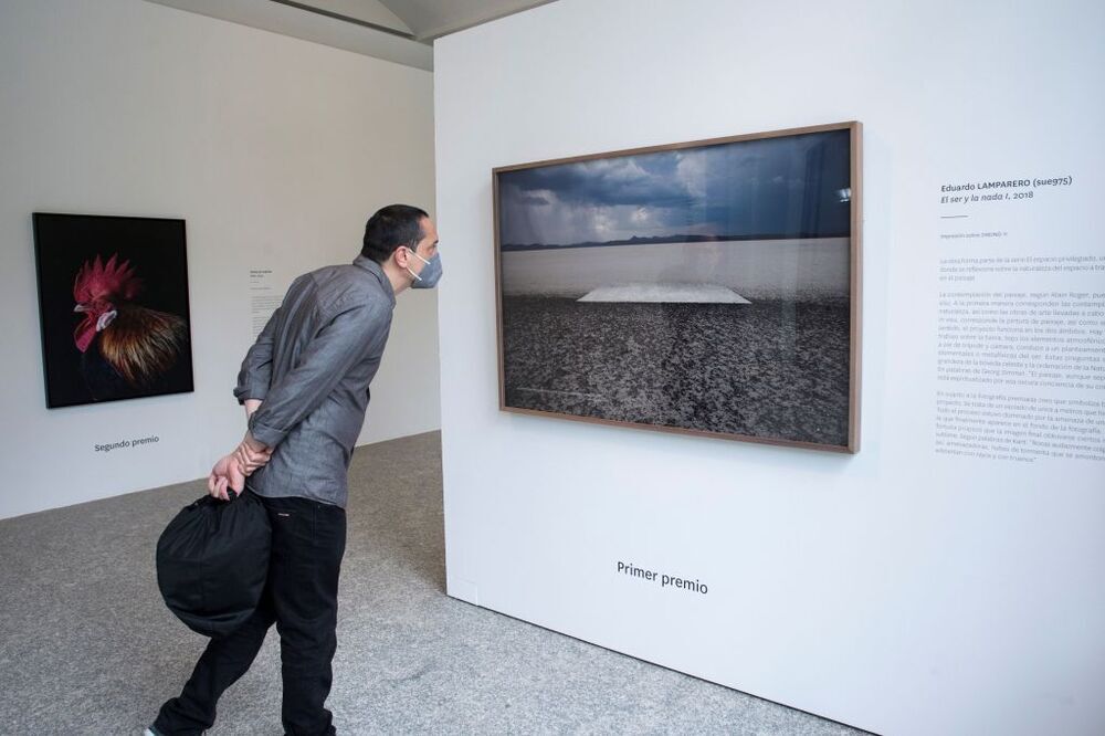 Un hombre observa los trabajos de los ‘Premios Fotografía de la Fundación ENAIRE’ en el Real Jardín Botánico de Madrid y que forma parte de PHotoESPAÑA. 