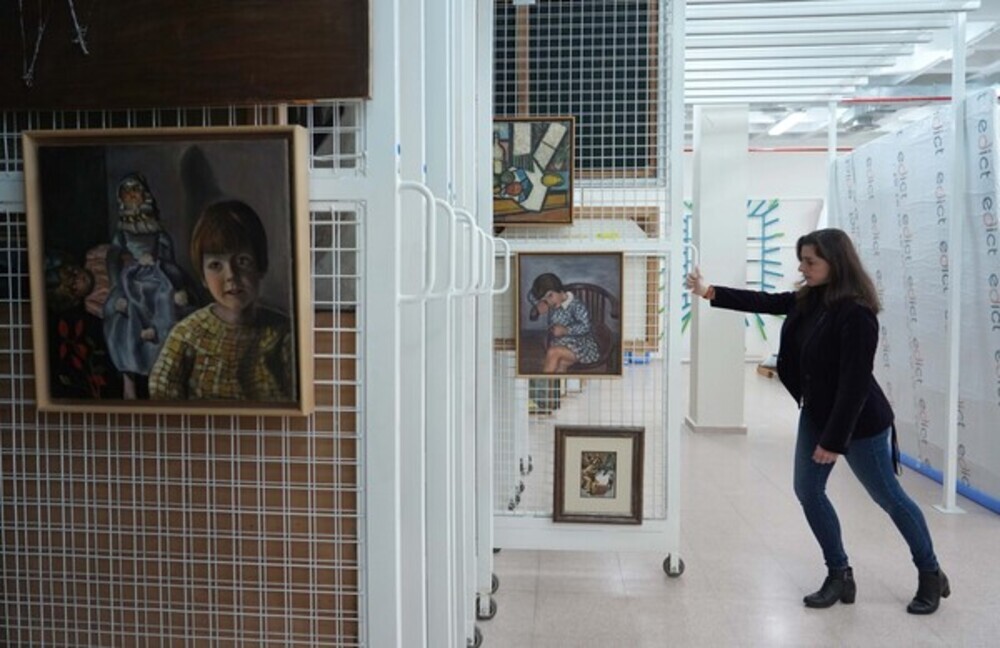 Beastriz Pastrana, conservadora de la Colección del Museo Patio Herreriano de Valladolid, muestra las obras de Ángeles Santos 'Nita (Anita y las muñecas)' y 'Anita con delantal de cuadros azules y blancos'.