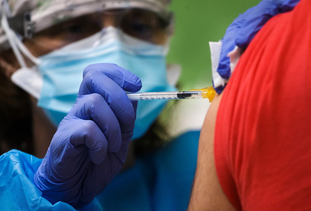 Una enfermera inyecta una vacuna.