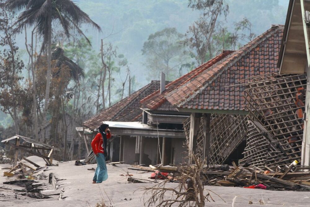 Villager stands near damaged houses affected by eruption of Mount Semeru volcano in Supiturang village  / ANTARA FOTO