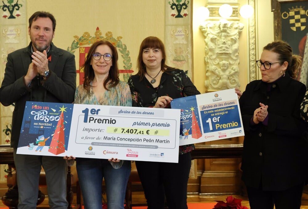 El alcalde de Valladolid, Óscar Puente, y la concejal de Innovación, Charo Chávez (dcha), entregan el premio a la ganadora del cheque para 6.000 euros en compras en el comercio de la ciudad. 