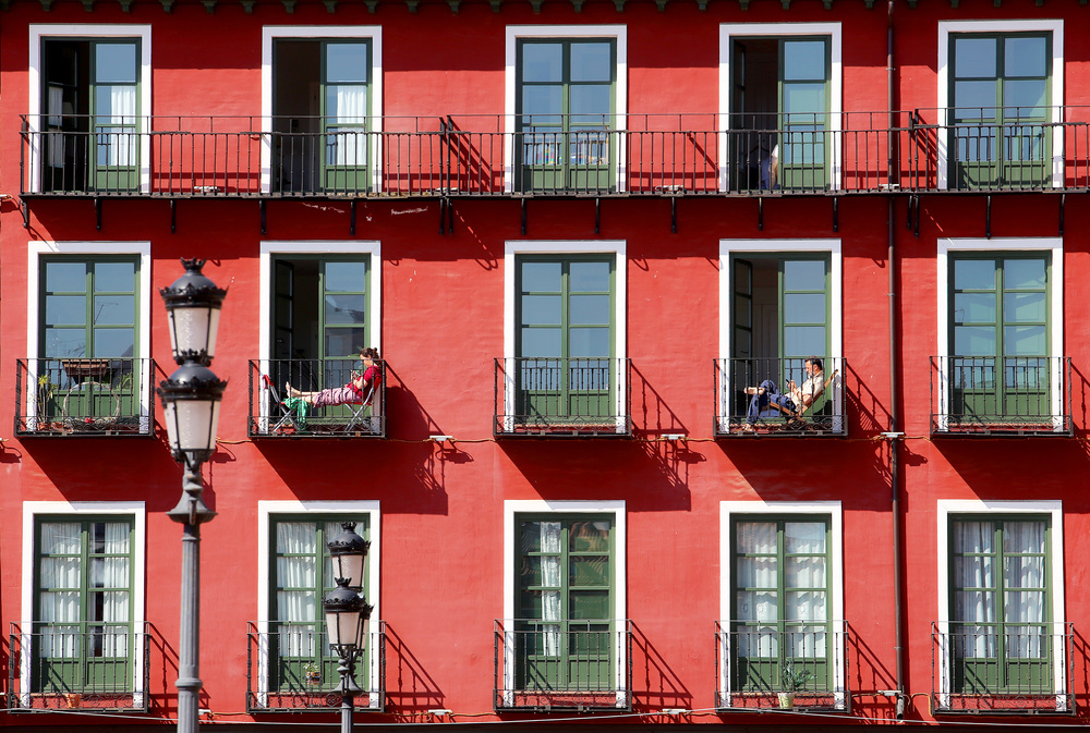 Dos personas descansan en el balcón de su vivienda durante el estado de alarma en Valladolid por la pandemia.