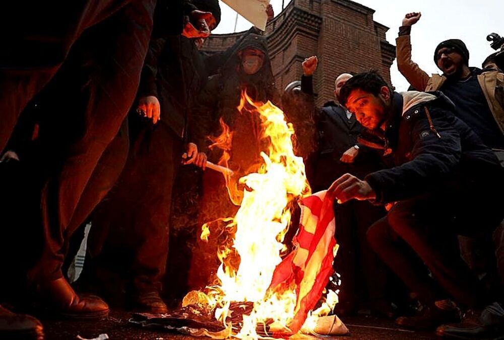 Un grupo de iraníes quema en Teherán la bandera de Estados Unidos, en respuesta a las sanciones de Occidente. 
