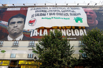Activistas antidesahucios cubren la pancarta Desokupa de Madrid
